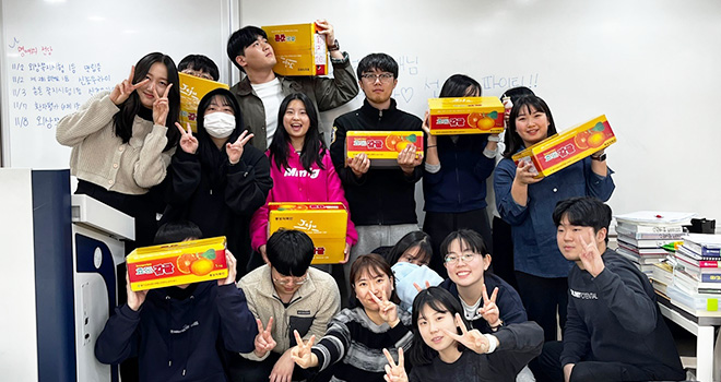 감귤박스를 들고 기념촬영을 하고 있는 학생들 모습